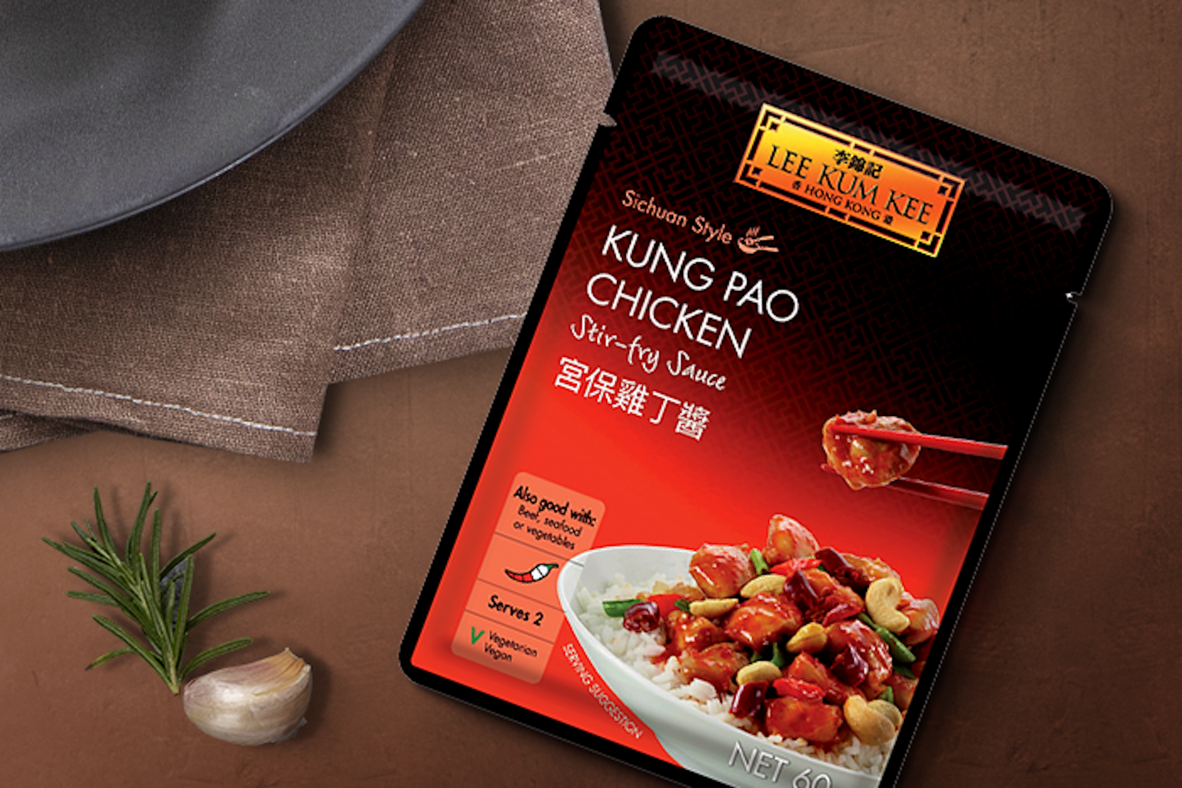 LEE KUM KEE Sauce neben Zutaten für Kung Pao Chicken wie Hühnchen, Paprika und Frühlingszwiebeln